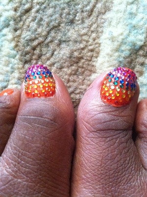 Using 1.5 mm rhinestones of multiple colors with a dark orange background I create a rainbow of color.