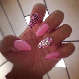 Pink nails with design on pointer finger and diamond accents.  