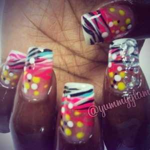Acrylic nails were free style designed to create a funky blend of electric colored dots and sexy Zebra patterns.  