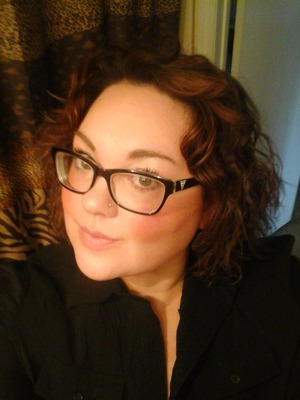 A natural  make up,  with curly hair and glasses 