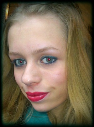 Blue-ish grey eye make-up with red lips and a peach blush.
