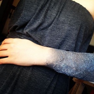 This is a look I did on myself for a Doctor Who event. It's intended to look like my arm is turning to stone.
I threw this together with toilet paper and elmer's glue. The color was done using black, grey, and white creams with a stippling brush.
