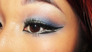 Dramatic cat eyeliner with blue in the crease and silver liner on the waterline
