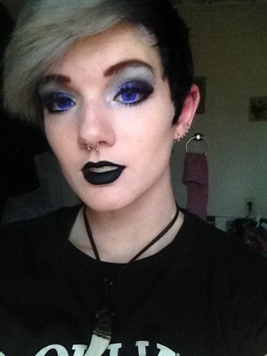 A more modern dark look with some purple accenting and a black lip.