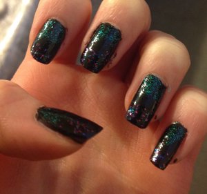 Black nails as a base, use sea foam green sparkles and purple and blue sparkles on either side. 
