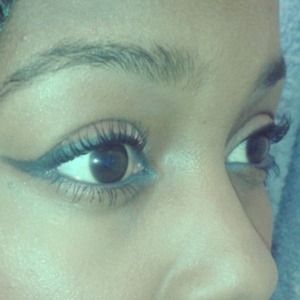 Blue eyeliner on bottom waterline with thick black wing eyeline on the top eyelid.