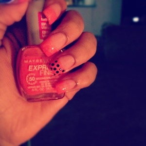 Acrylic nails with a peach pink & black polka dots.