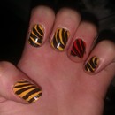 Yellow nails with orange accent nails and diagonal black stripes
