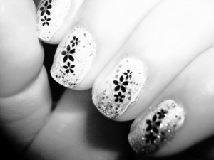 1.White nail polish
2. Top with glitter polish 
3. Top with black flower nail stickers