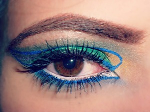 first i made a line with a green pencil in the mobile eyelid to divide the colours. Then i applied a green pencil (ULTIMAII 05) as a base and i put on it a deep green shadow (sephora). After i made, little bit over the crease, a line with a blue eyeliner (revlon colorstay liquid eyeliner 05 royal), then i applied just under this i applied a yellow shadow (which i don't know the brand but it's n° 13 sunny yellow) in the crease in the first half and in the second half a violet (kiko cosmetics) then over the blue eyeliner i made a teal shadow. With the blue eyeliner i make an arabic drawing in the inner corner. Finally i put a white pencil (mastemi 38) inside the eye.