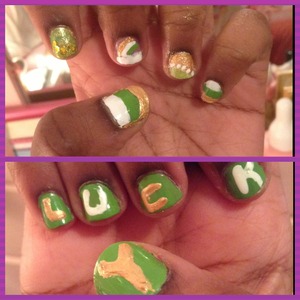 Designs on left hand. The word "LUCKY" on the right. Made with green and white nail polish and gold acrylic paint. 