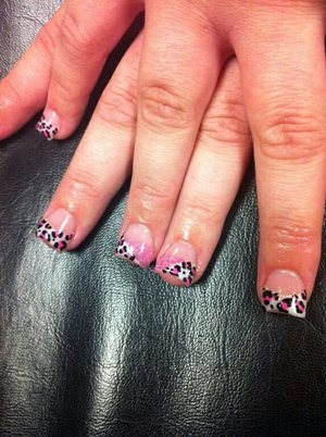 Acrylic nails with tips, with leopard print design, with one nail split in half with glitter and leopard print. 