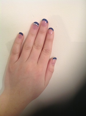 Navy French manicure with rhinestone detail on ring finger