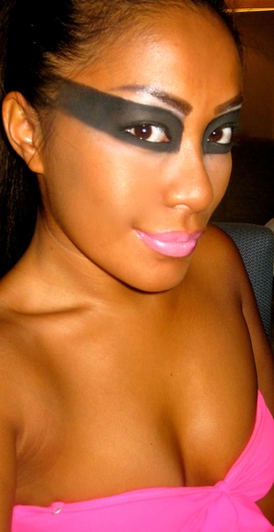 Deep smokey eyes with a dark carbon eyeshadow, skin goldy brown and pink lipstick. 