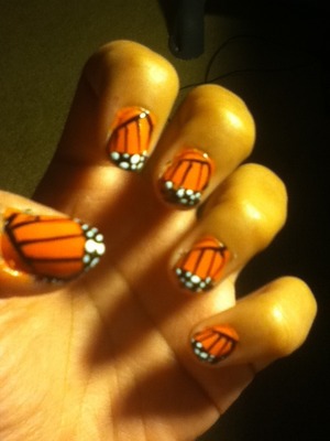 An older design I did a while back. It's a cute monarch butterfly design. Fun and simple. Here's how to do it :
1. As always a base coat to protect the nail
2. Paint your nails orange
3. just slightly above the bottom corner of one of your nails draw a small line with a black striper. 
4. Then from that line draw 3-4 lines reaching across to the other side
5. On the corner where all the lines are meeting draw another Black line, and fill it in so you cover the other lines (confusing I know but hopefully looking at the pic will help) 
6. Lastly, draw a couple of white dots on the filled in black part and your done
Hope you have fun recreating this! 