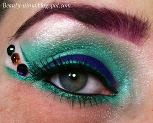 Shadows: Coastal Scents - Queens Jubilee, Tropic Green & Purple Panic. MUG - Shimma Shimma on browbone. The white at the side is from WnW's Drinking a Glass of Shine palette. 
Liners: WnW liquid liners in teal & black. UD 24/7 pencil in Perversion. 
Lashes: I have no idea!! :(
Brow: Anastasia Beverly Hills Hypercolor Brow & Hair powder in Ultra-Violet. 
Rhinestones are from the craft section at Walmart, stuck on with lash glue. 
