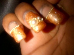 Here my nails are polished with a bronze shimmery polish, designed with half cut pearls and lined with gold beads