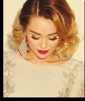 Miley's pin up look. Cat liner, red lips, highlighted skin.