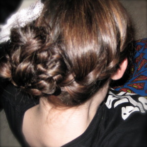 Started french braid at the side, continued on to the back into a low side pony tail. Split ponytail into two, looped ribbon through and braided both strands, elastic at bottom. Pull up on the ribbon and braid will bunch, cut the ends of the ribbon (not your hair!) twist and pin in place.