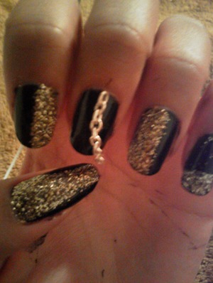 black nail polish and gold glitter and chain 