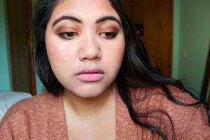 Simple burnt orange eyeshadow, brown in the crease, and golden glitter on the lid, rosy cheeks and pale pink lips. 