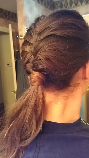 French Fishtail braid down until nape of neck. 
Secure with clear elastic. 
Take a small piece of hair and wrap it around ponytail. 