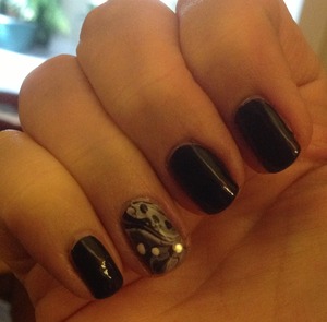Black nails with black/white water marbling on the ring finger.