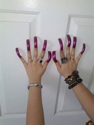 My very long and curved acrylic nails, polished with deep purple lacquer; applied professionally at the salon. A bold statement.