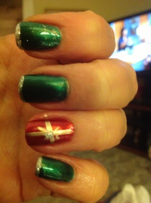 OPI in both green and red.  Silver glitter as tips.  Gold used to make ribbon on the red nail and a dot of silver glitter in the middle.