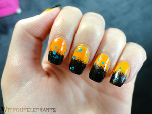 Orange and black gradient nails with blue glitter