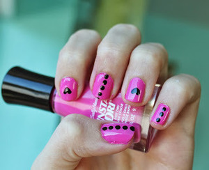 A nail design featuring hearts and dots. 
