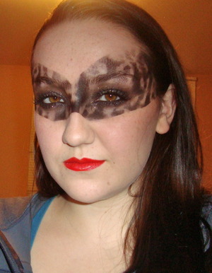 using lace as a stencil. i first mapped out where i wanted it to appear with tape, then stippled on carbon eyeshadow over the stencil all over. then used a black shimmery cream eyeshadow on the lids and blended out. used some spikey lashes to top it off!