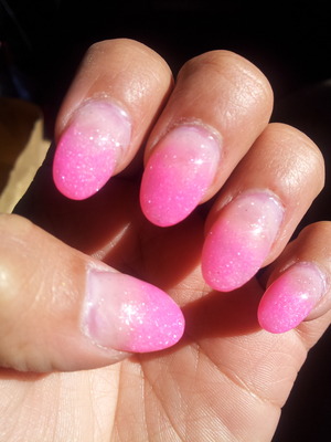 Oval shaped nails. With a pink glitter fade effect. 