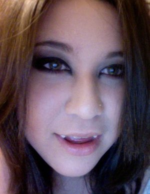 purple eyeshadow,with black ontop, a grey eyeshadow on crease with white high light, purple shadow on bottom of eye, heavy black eyeliner and heavy black mascara, light blush on cheeks.