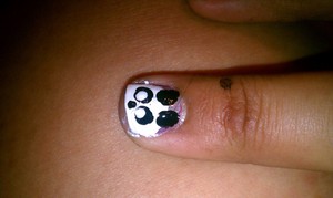 using white and black and a dotting tool. Paint a white half circle from tip to mid nail then make ears with two large dots towards the top of the nail then make the eyes with 2 black dots allow to dry then make a smaller white dot in the black eyes, for nose make a small black dot under eyes