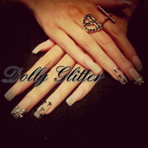 baby pink/ nude acrylics with painted crosses and skull decorations.