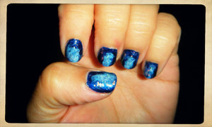 Used a dark blue polish first, then with a piece of a make up applicator sponge I added white to the middle and a lighter blue around the edges of the white. Topped it with China Glaze Luxe and Lush flakes polish and a top coat. Looks so pretty in direct light. 