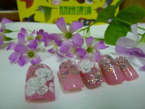上兩層粉紅色的指甲油，再局部上璀璨指甲油，接著畫粉雕花朵，最後貼上珍珠與水鑽及亮片。