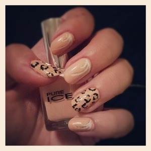 Nude polish with black and gold glitter leopard print, and white accents with gold glitter. 