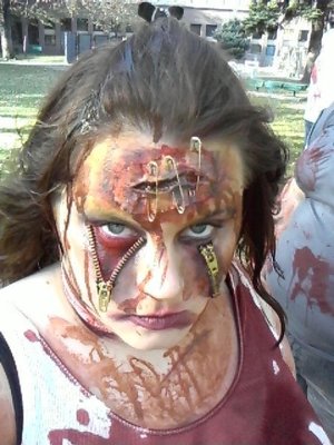 I just used zippers from walmart, cut the fabric off of them, used spirit gum to stick them on and then used fake blood and some yellow and purple eye shadow to do some contouring and bruise work. 