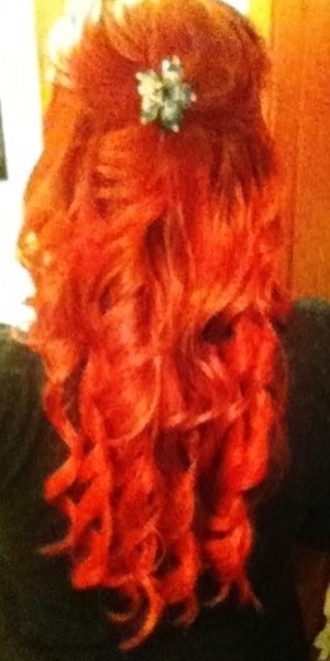 Vivid red curls with contrasting turqouise hairpiece.
