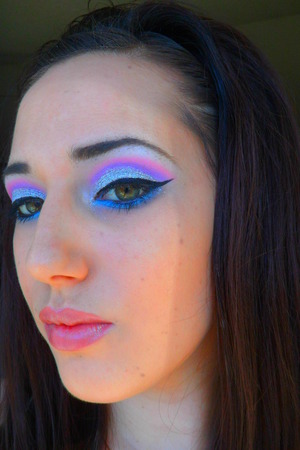 Silver glitter on the lid, purple in the crease with pink blended on top. Dramatic winged out liner and blue on lower lash line.