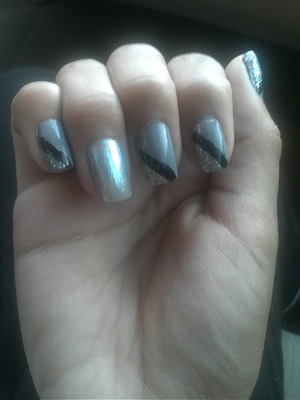 freehanded lines.  gray nails with a black lines and some silver glitter. one finger has a shiny silver Polish 
