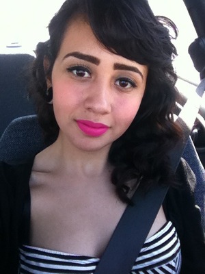 Bright pink lips . Eye liner and fake eyelashes. and little blush. Curled hair 