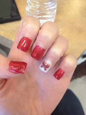 Cute red and white Christmas nails with a bow on one.