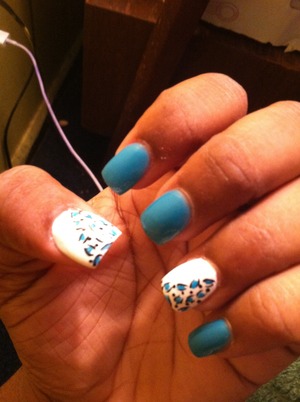 Blue and white nails with black and blue cheetah print going diagonal on the white nail 