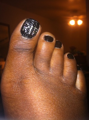 Using black and iridescent clear rhinestones to create the RIP big toe nail design.