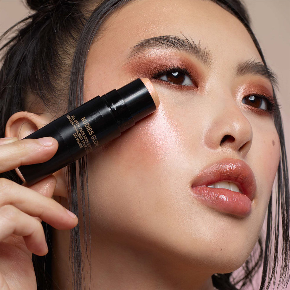 Nudestix model wearing the Nudies Glow Highlighter Stick in Euphorix