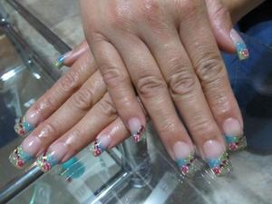 These are acrylic nails. All I used was acrylic glitter (blue, green, yellow & pink). Added some fimo flowers & small red rhinestones.