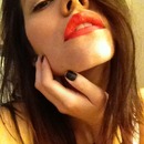 Red-orange lip, white eyeliner, matte black nails